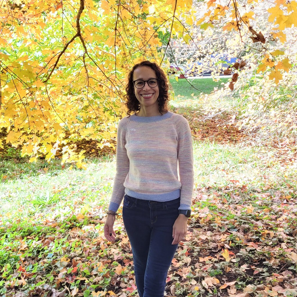 A picture of Jessie Mae Maimone under a canopy of yellow fall leaves